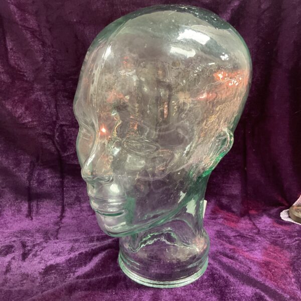 Clear vintage glass display head for hats and wigs.