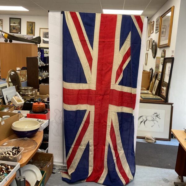 Large vintage Union Jack flag panel displayed indoors.