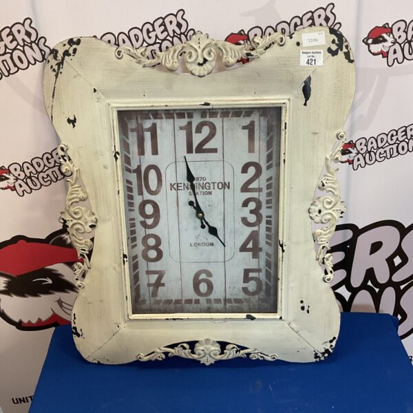 Vintage Kensington station enamel clock with black numerals.