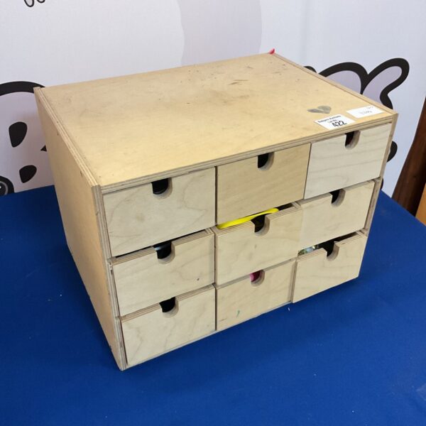 Stack of vintage wooden desk drawers for office storage.