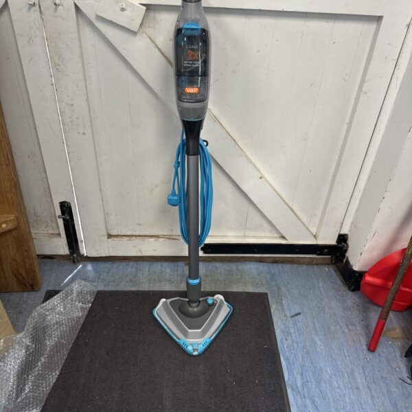 Blue and grey Vax steam mop standing on a black mat.