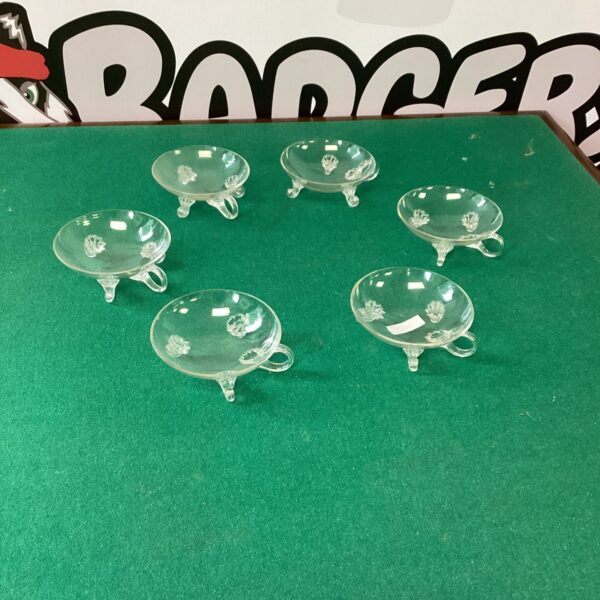 Set of six vintage champagne coupes on a patterned surface.