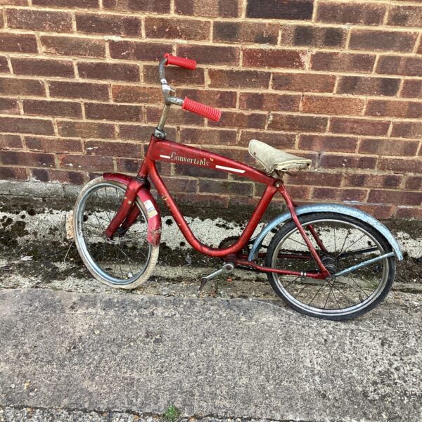 Red vintage childs convertible bike for restoration project.