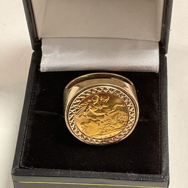 Close-up of a gold half sovereign ring with St George design.