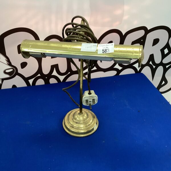 Vintage brass desk lamp with adjustable arm and circular base.