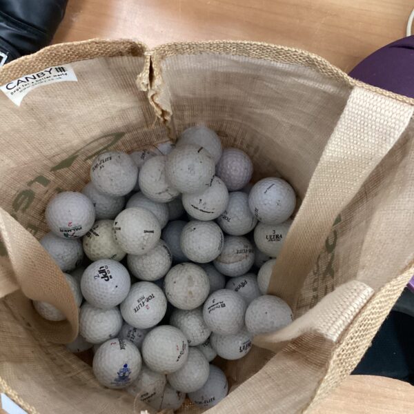 White used golf balls in a bag, golf equipment.