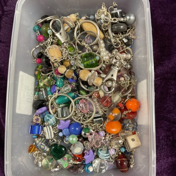 Tray of mixed vintage and modern charms and keyrings.