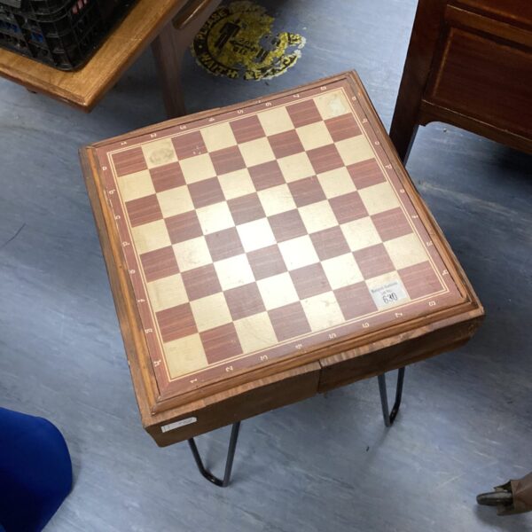 Vintage chess table with wire legs and a classic chessboard.