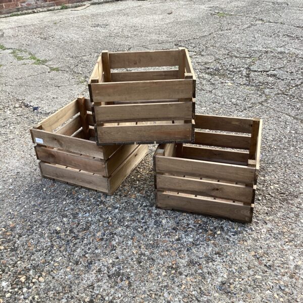 Three vintage wooden fruit crates for rustic storage.