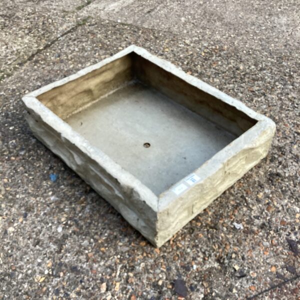Stone effect fibreglass planter for garden or patio display.