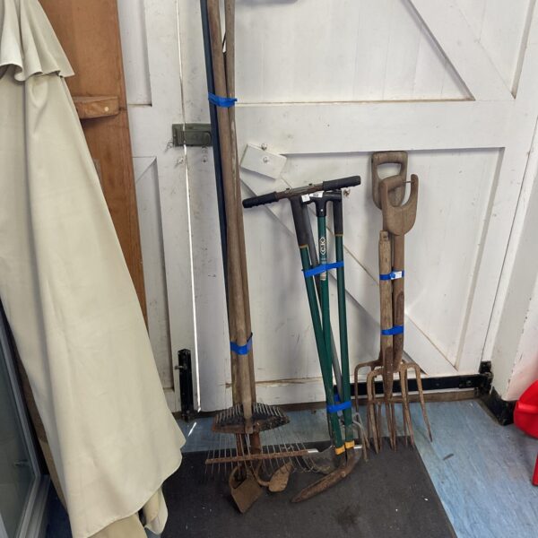 Vintage garden tool lot including forks and hoes.