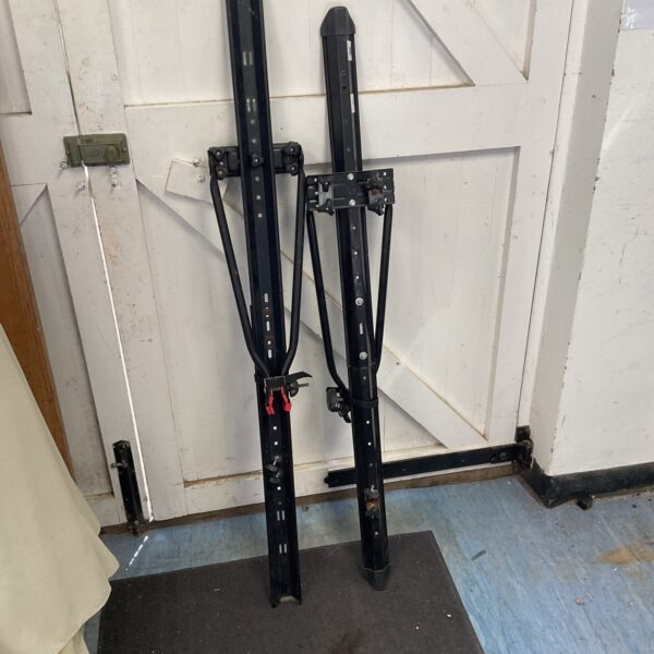 Metal car roof rack cycle bars for bicycle transport.