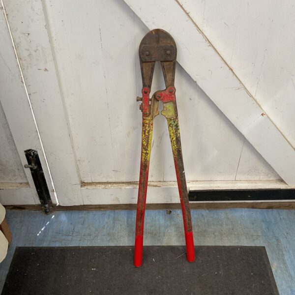 Large bolt croppers with red handles, a heavy duty metal cutting tool.