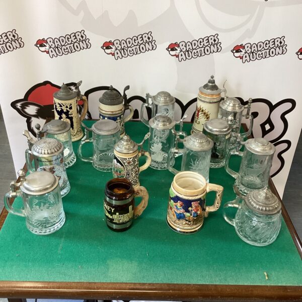 Lot of vintage German beer steins with varied designs.