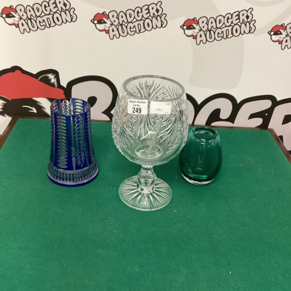 Vintage cut glass golf trophy with colourful Murano vases displayed.