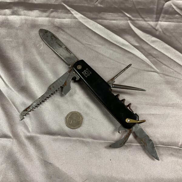 Vintage red-handled Swiss Army Pradel pocket knife with tools extended.
