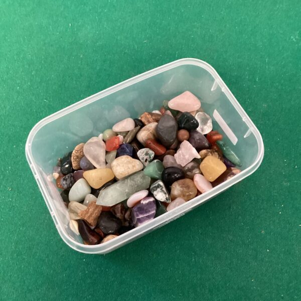 Clear container filled with a colourful polished stones collection.