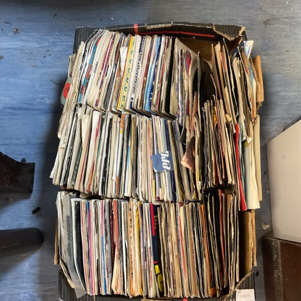 Stacked lot of vintage 7 inch vinyl records for collectors.