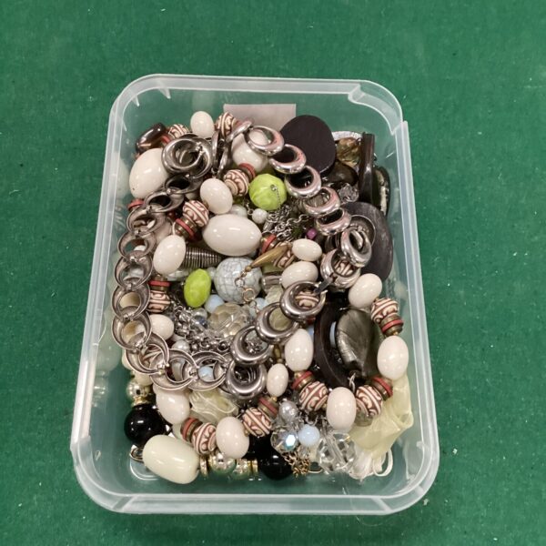Costume jewellery necklaces in a plastic tray, colourful and varied.
