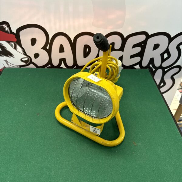 Vintage 110v site light with yellow casing and protective cage.