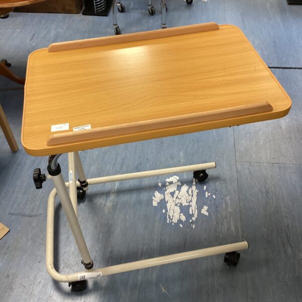 Adjustable bedside table on wheels with laminate top.