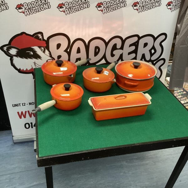 Vibrant orange Le Creuset casserole dish set on display.