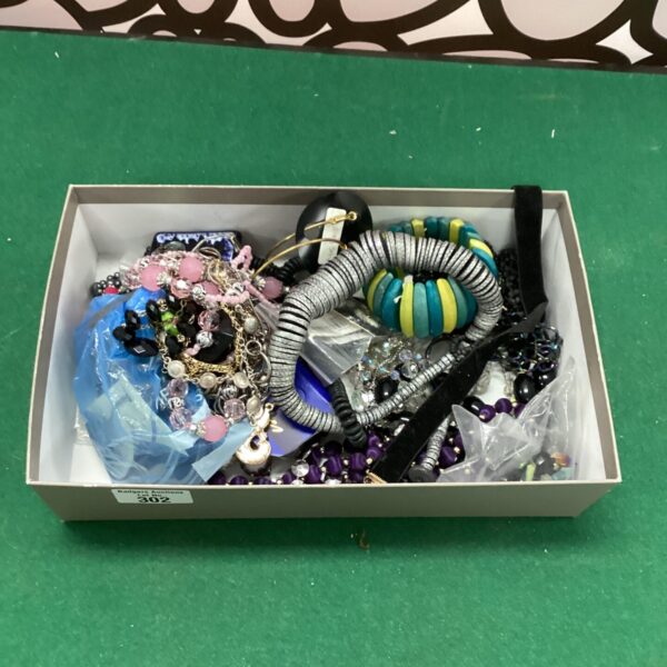 Close-up of a colourful costume jewellery lot with a beaded necklace and brooch.