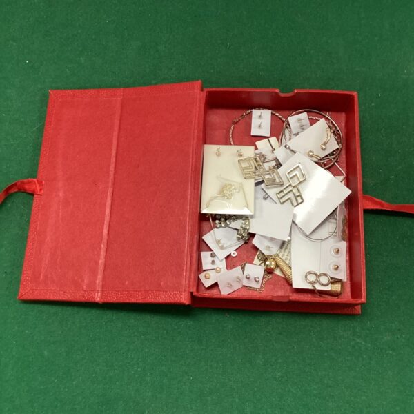 Red box containing a collection of fashion earrings.