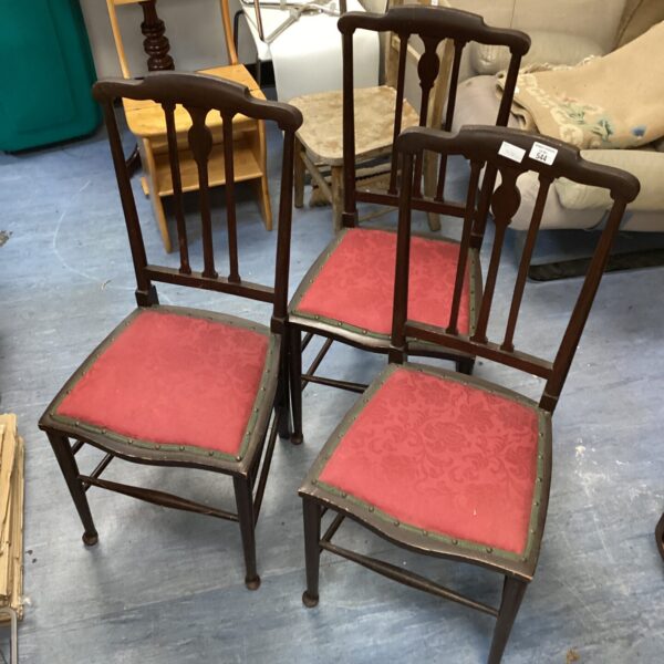 Three vintage fabric covered chairs with patterned upholstery.