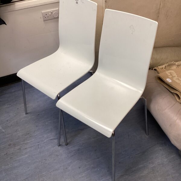 Two white designer style chairs with chrome legs.