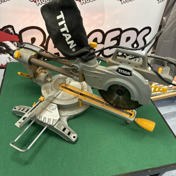 Used Titan chop saw for cutting metal in a workshop setting.