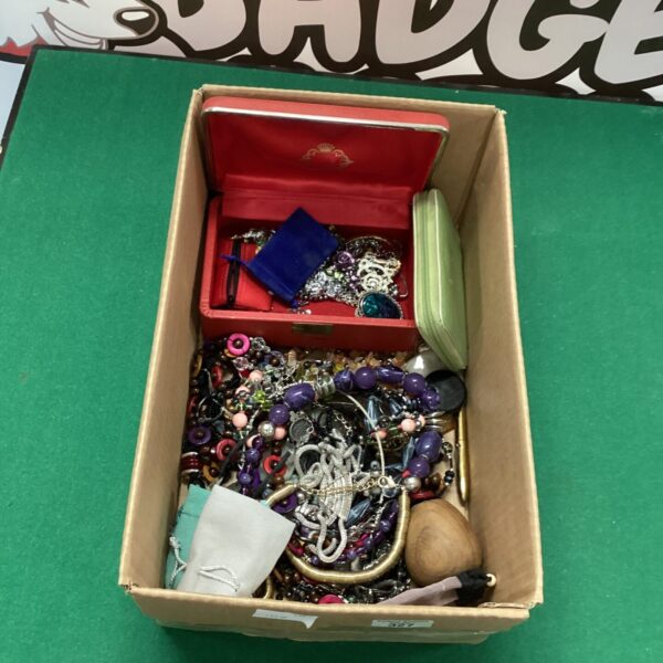 A box filled with a colourful assortment of costume jewellery pieces.