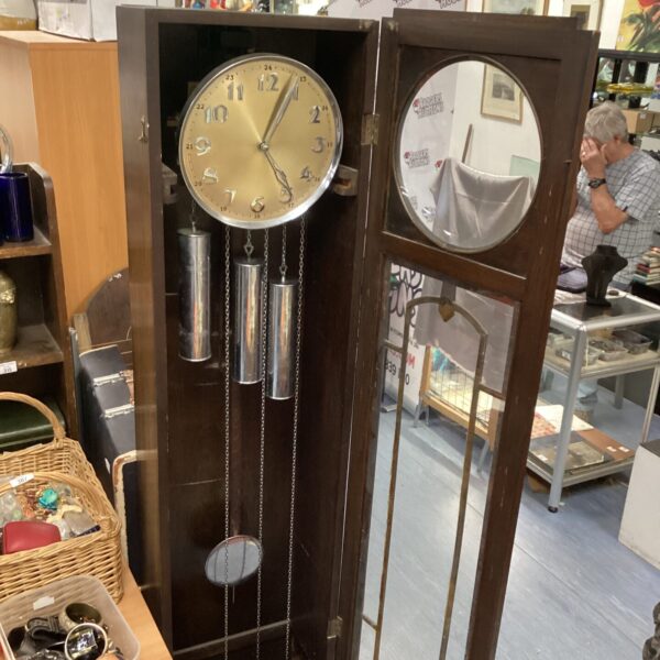 Antique Art Nouveau longcase clock with visible pendulum and ornate face.