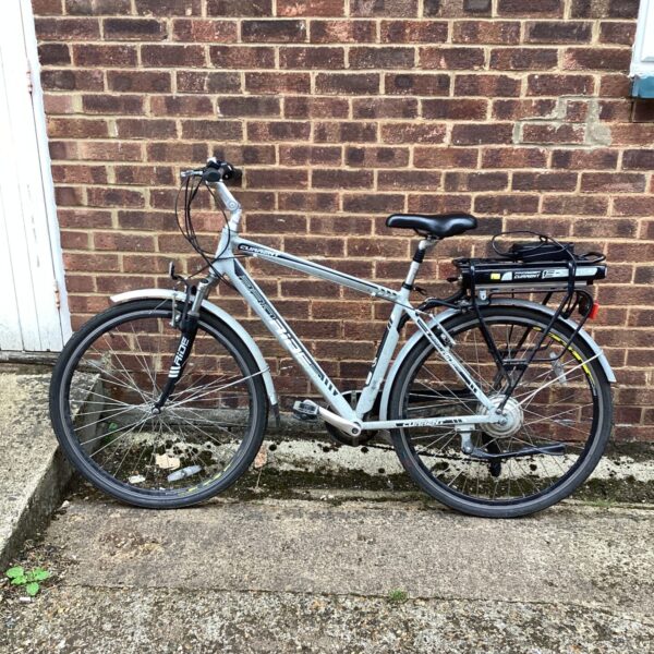 Silver Proride Current electric bike with battery and mudguards.
