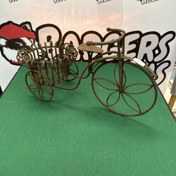 Vintage wrought iron tricycle plant stand for garden display.