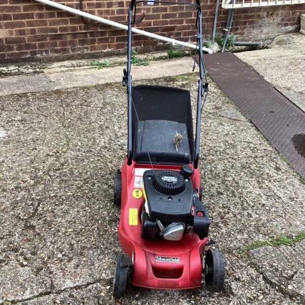 Red Mountfield RS100 lawn mower in a garden setting.