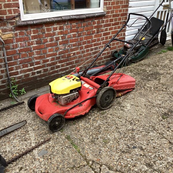 Vintage Wolf 625 lawn mower in a garden setting.