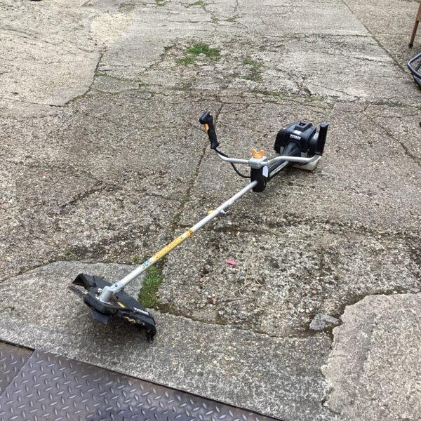 Used Titan petrol strimmer in a garden setting.