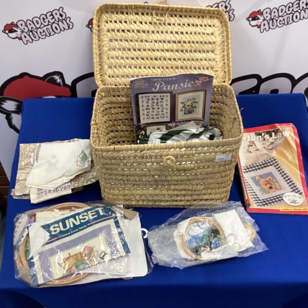 Wicker basket filled with cross stitch magazines and crafting materials.