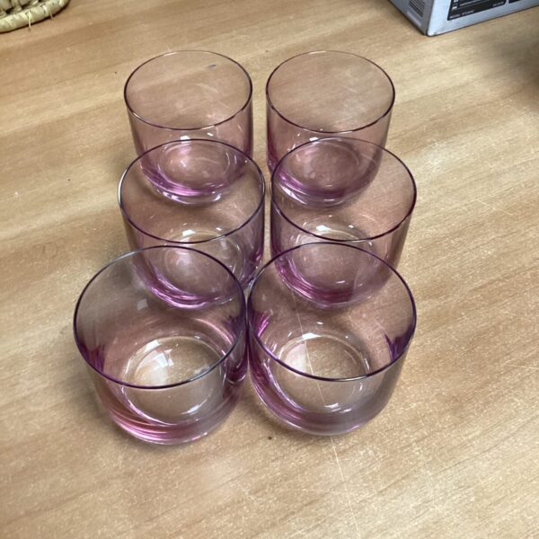 Set of six vintage lilac glass tumblers on a light surface.
