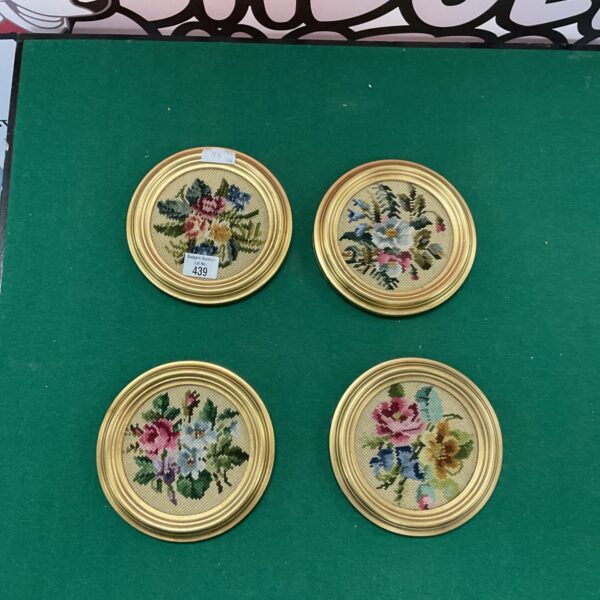 Vintage tapestry panels with delicate floral designs in golden frames.