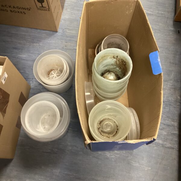 Mixed lot of glass and plastic plant pots for gardening.