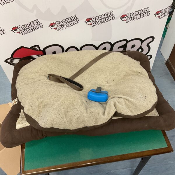 Portable dog bed with integrated lead and treat pouch.