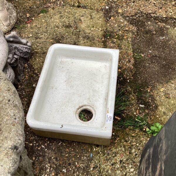 Vintage small belfast sink with central drain hole.