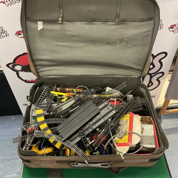 Vintage suitcase filled with Hornby model train track pieces.