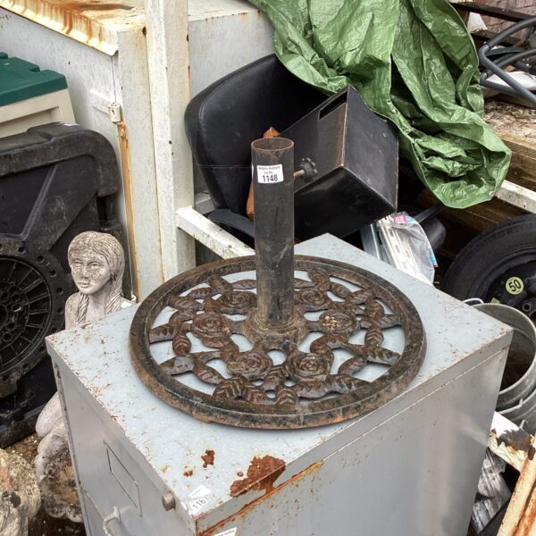Vintage wrought iron parasol base with floral detailing for garden use.