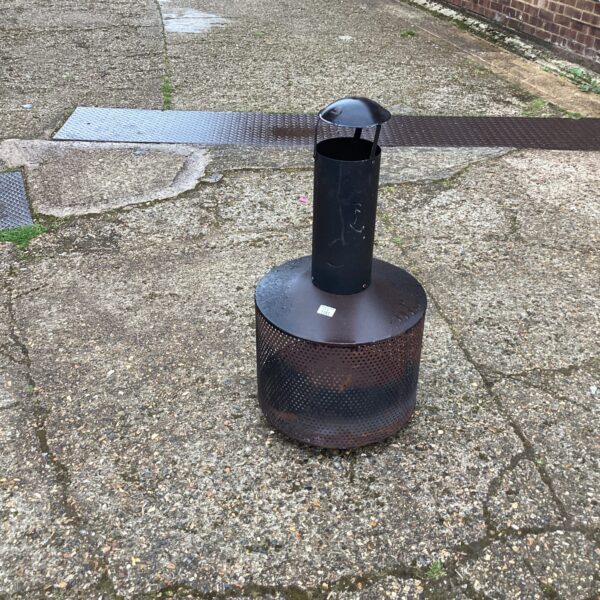 Rustic metal garden fire pit for outdoor use.
