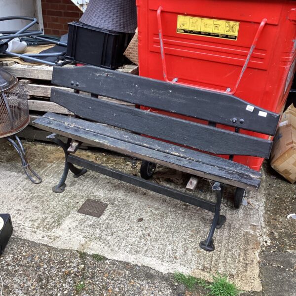 Rustic wooden garden bench needing repair in a garden setting.