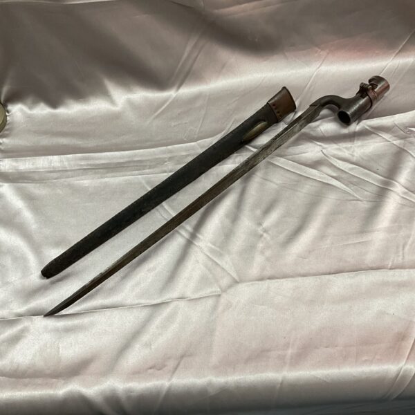 Antique 1853 Enfield bayonet with leather scabbard, detailed view.