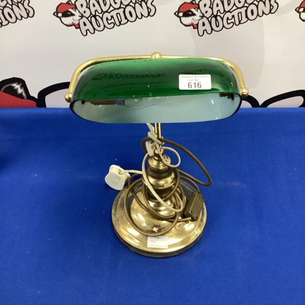 Antique brass bankers lamp with a green glass shade.